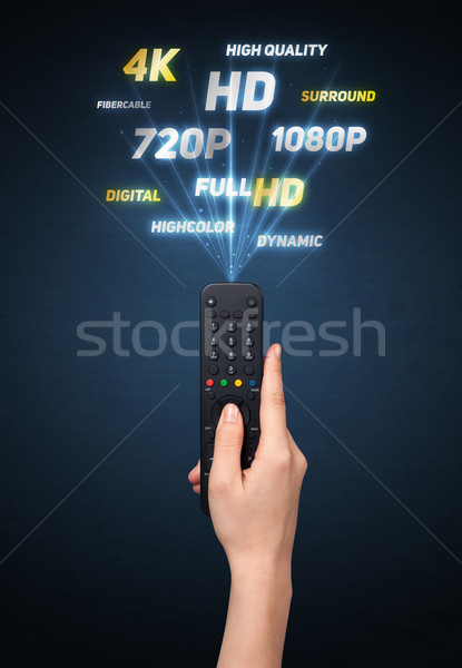 Hand with remote control and multimedia properties Stock photo © ra2studio