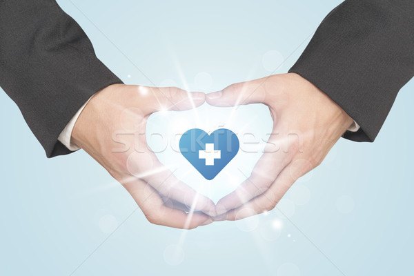 Hands creating a form with heart blue cross Stock photo © ra2studio