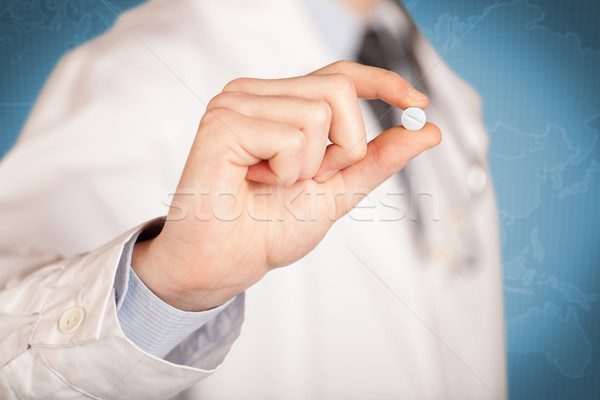 Doctor in white holding a pill Stock photo © ra2studio