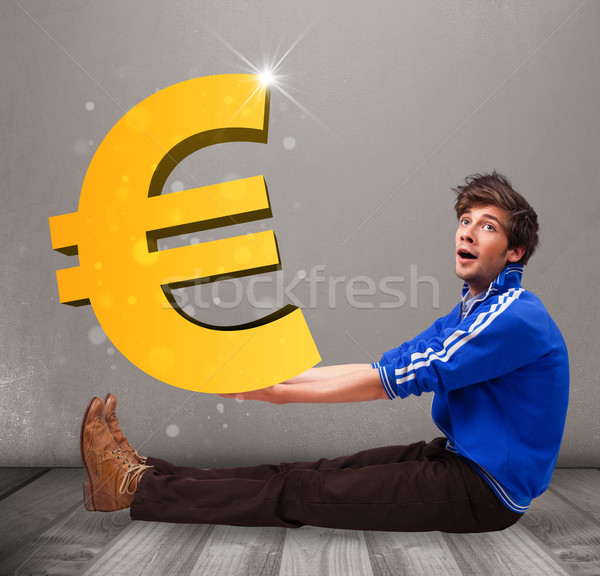 Good-looking boy holding a big 3d gold euro sign Stock photo © ra2studio