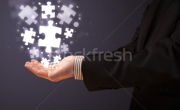 Puzzle pieces in the hand of a businessman Stock photo © ra2studio