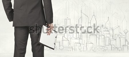 Businessman with drawn city view Stock photo © ra2studio