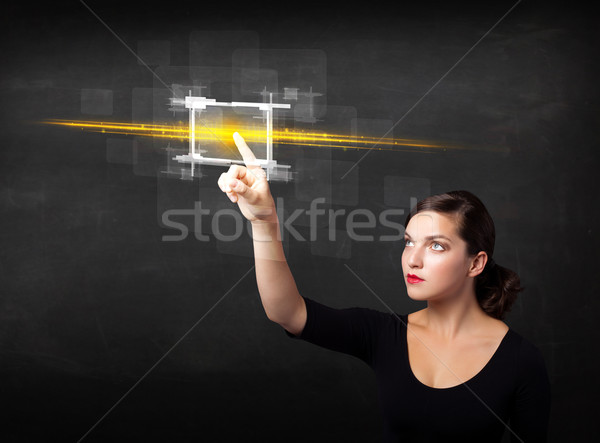 Young tech lady touching button with orange light beams concept Stock photo © ra2studio
