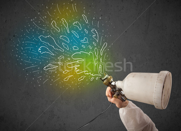 Worker with airbrush gun paints colorful lines and splashes Stock photo © ra2studio