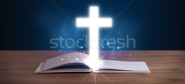 Stock photo: Open holy bible with glowing cross in the middle