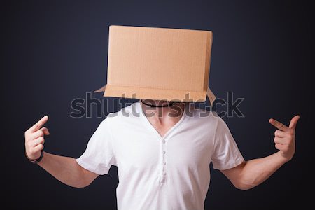 Young girl gesturing with a cardboard box on his head Stock photo © ra2studio
