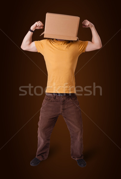 Young man gesturing with a cardboard box on his head Stock photo © ra2studio