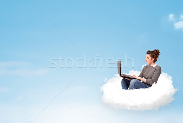 Young woman with laptop sitting on cloud with copy space Stock photo © ra2studio