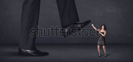 Giant person stepping on a little businesswoman concept Stock photo © ra2studio