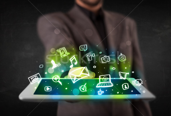 Person holding a tablet with media icons and symbols Stock photo © ra2studio