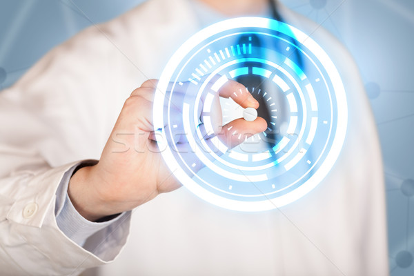 Male doctor holding a pill with glowing circles Stock photo © ra2studio