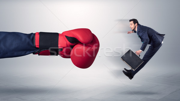 Giant hand gives a kick to a small businessman Stock photo © ra2studio