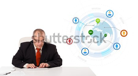businessman sitting at desk with a globe and social icons Stock photo © ra2studio