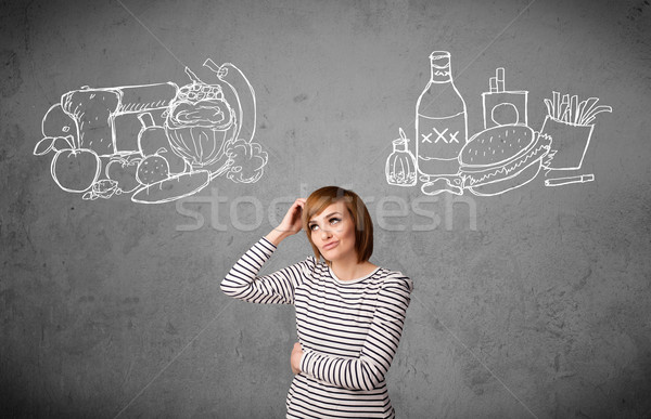 Woman standing between healthy and unhealthy foods Stock photo © ra2studio