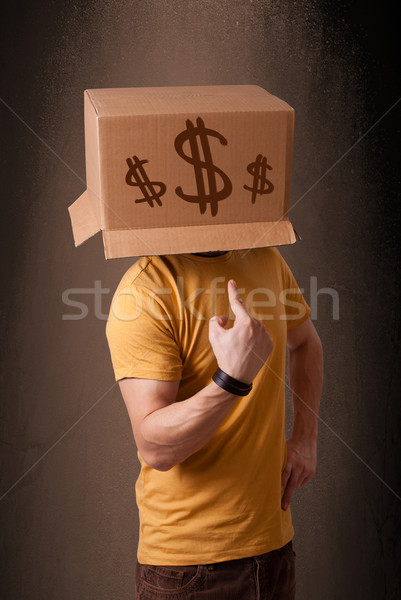 Young man gesturing with a cardboard box on his head with dollar Stock photo © ra2studio