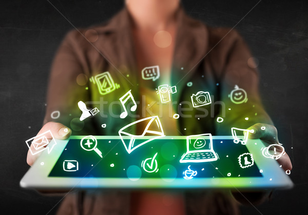 Person holding a tablet with media icons and symbols Stock photo © ra2studio