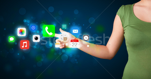 Young businesswoman pressing colorful mobile app icons with boke Stock photo © ra2studio