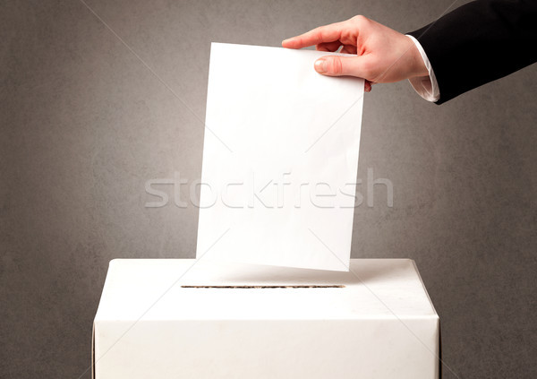 Stock photo: Ballot box with person casting vote 