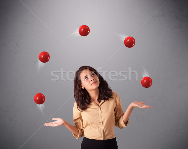 Stock photo: young girl standing and juggling with red balls