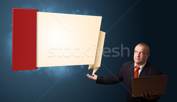 Businessman in suit holding a laptop and presenting modern origami copy space Stock photo © ra2studio