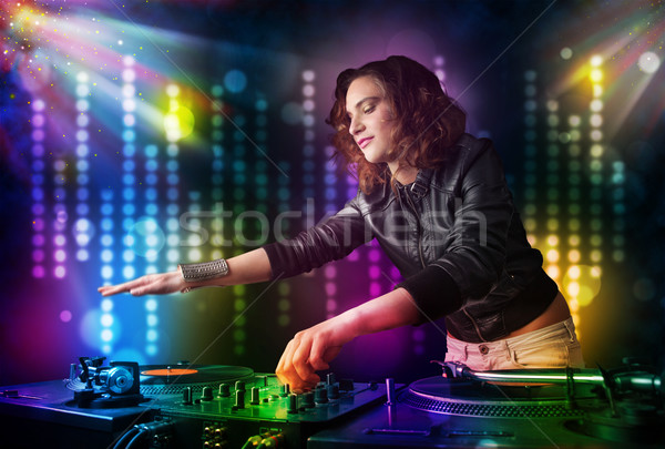 Dj girl playing songs in a disco with light show Stock photo © ra2studio