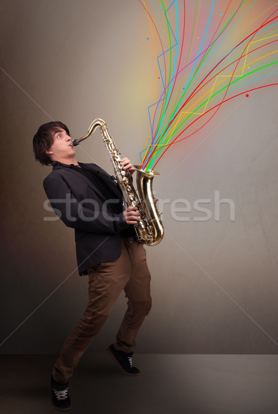 Attractive musician playing on saxophone while colorful abstract Stock photo © ra2studio