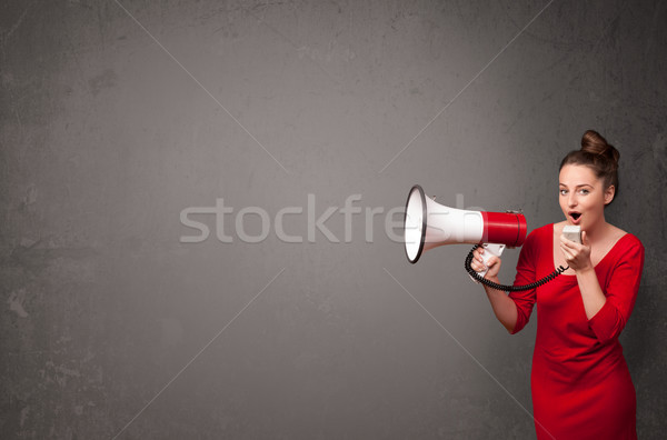 Stock photo: Girl shouting into megaphone on copy space background