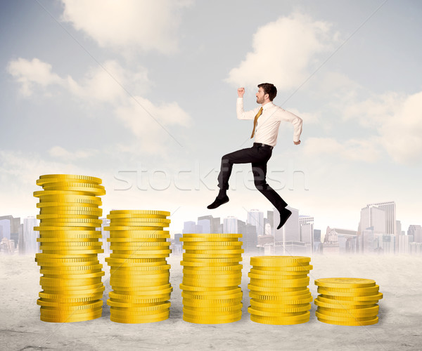 Bem sucedido homem de negócios saltando para cima moeda de ouro dinheiro Foto stock © ra2studio