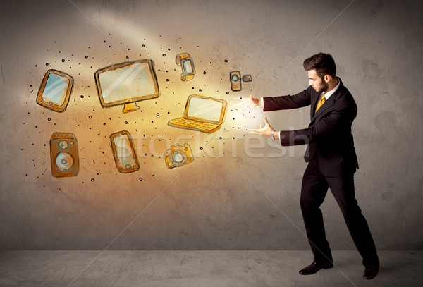 Stock photo: Man throwing hand drawn electronical devices 