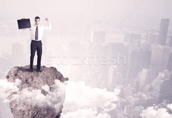 Winner business person standing on rock Stock photo © ra2studio