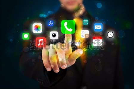 Handsome businessman pressing colorful mobile app icons with bok Stock photo © ra2studio