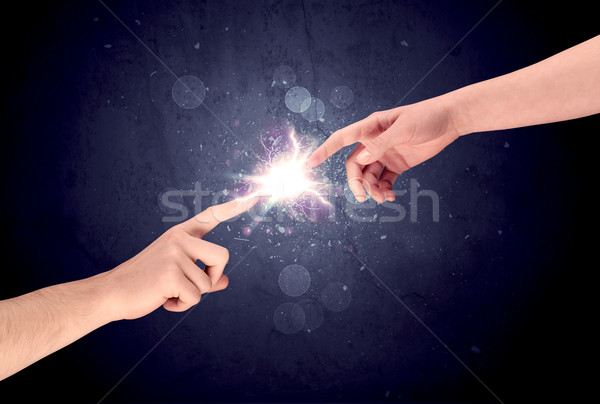 Hands reaching to light a spark Stock photo © ra2studio