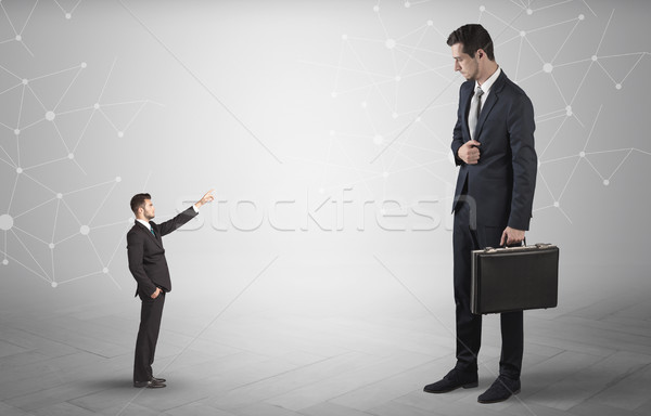 Small man aiming at a big man with network concept Stock photo © ra2studio