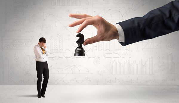 Stock photo: Businessman is afraid to make the next step in a chess game with graphs background