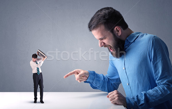 Young businessman fighting with miniature businessman Stock photo © ra2studio