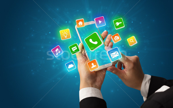 Stock photo: Hand using phone with shiny application icons