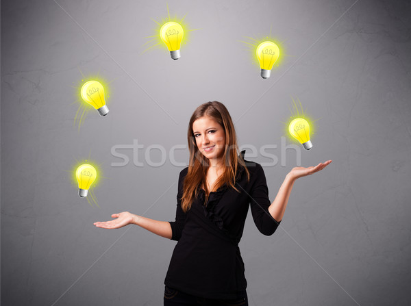 young lady standing and juggling with light bulbs Stock photo © ra2studio