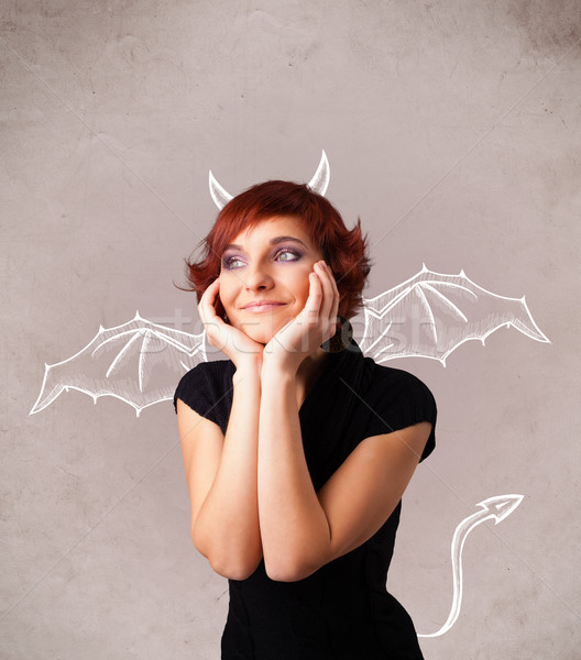 Young girl with devil horns and wings drawing Stock photo © ra2studio