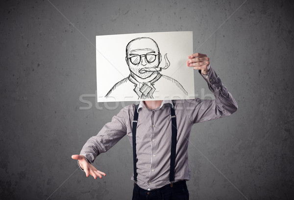 Businessman holding a cardboard with a smoking man on it in fron Stock photo © ra2studio