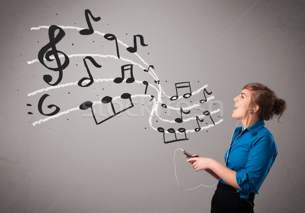 attractive young lady singing and listening to music with musical notes Stock photo © ra2studio