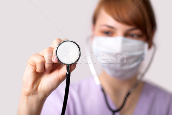 Female doctor holding stethoscope pointed toward camera Stock photo © ra2studio