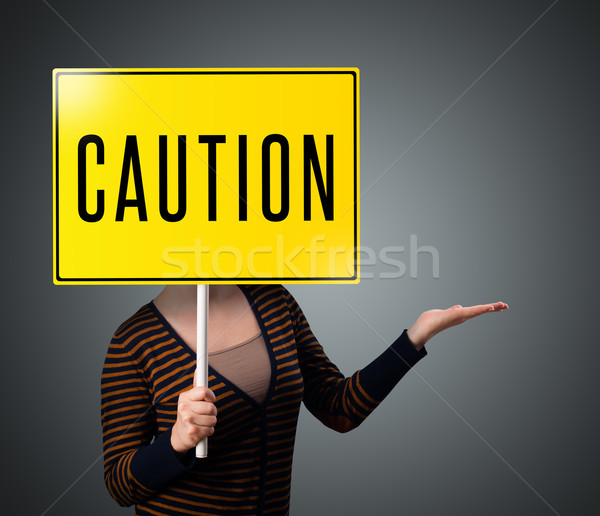 Young woman holding a caution sign Stock photo © ra2studio