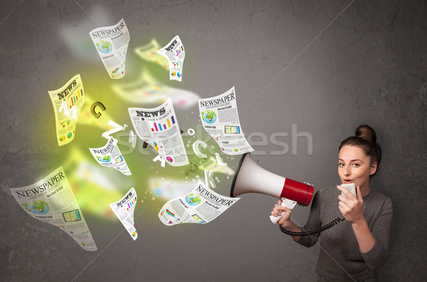 Girl yelling into loudspeaker and newspapers fly out Stock photo © ra2studio