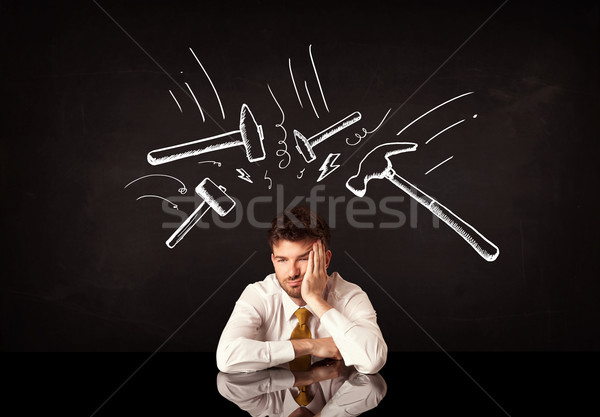 Depressed businessman sitting under hammer marks Stock photo © ra2studio