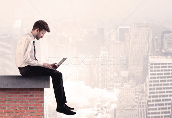 Office worker sitting on rooftop in city Stock photo © ra2studio