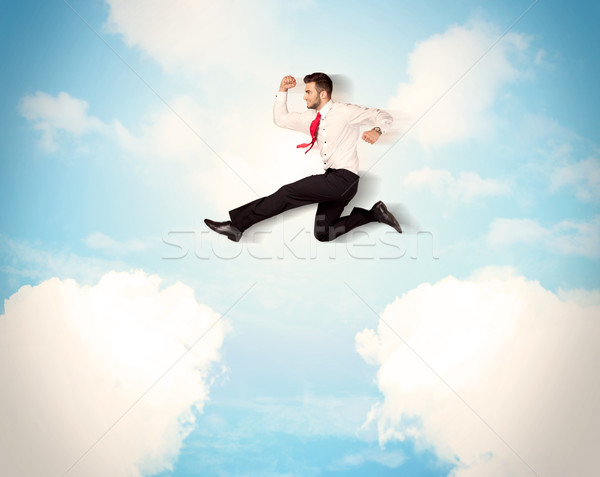 Business person jumping over clouds in the sky Stock photo © ra2studio