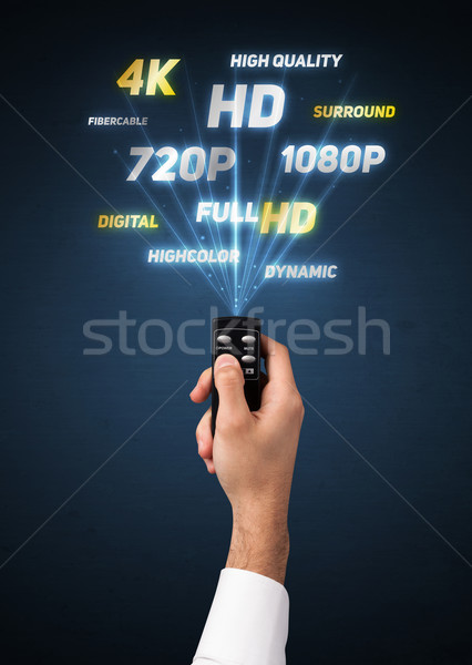 Hand with remote control and multimedia properties Stock photo © ra2studio