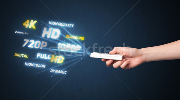 Hand with remote control and multimedia properties Stock photo © ra2studio