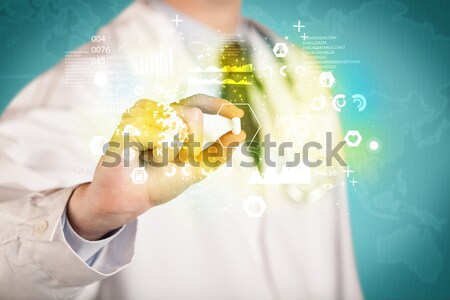 Doctor holding a pill between fingers Stock photo © ra2studio