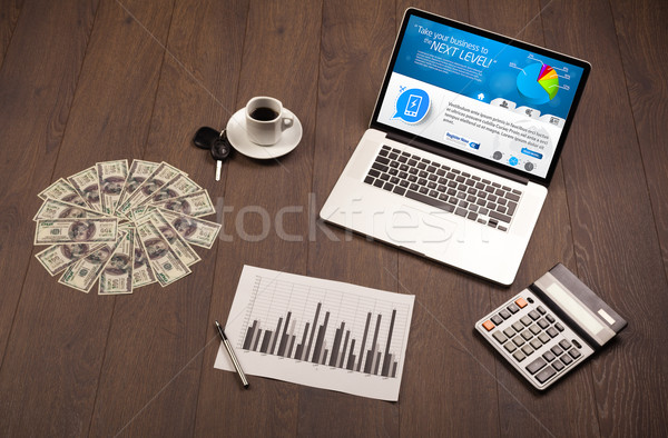 Laptop on office desk with business website on screen Stock photo © ra2studio